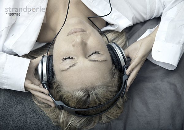 Junge Frau hört Musik mit Kopfhörern