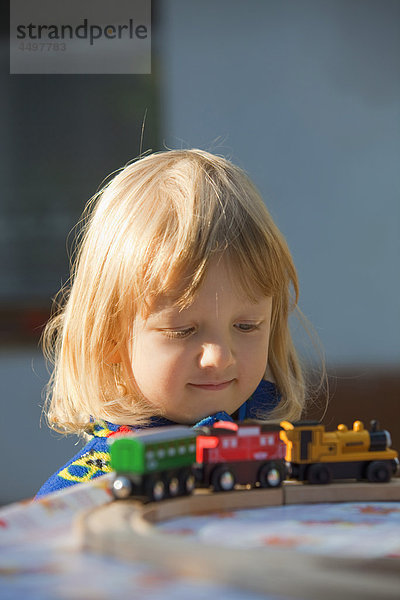 Blond  jungen  Kind  Kindheit  konzentrierte  enge  Niedlich  Spaß  Garten  Kid  Haar  suchen  outdoor  Außenaufnahme  spielen  Spielzeug  Zug