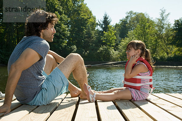 Vater und Tochter am Steg im See