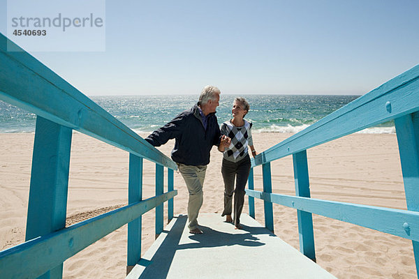Erwachsene Paare  die am Strand spazieren gehen.
