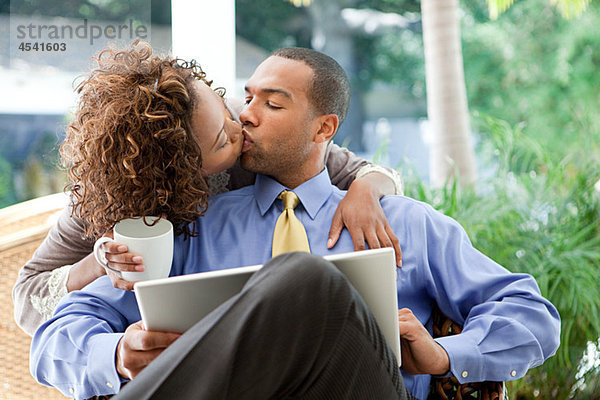 Küssendes Paar mit Laptop