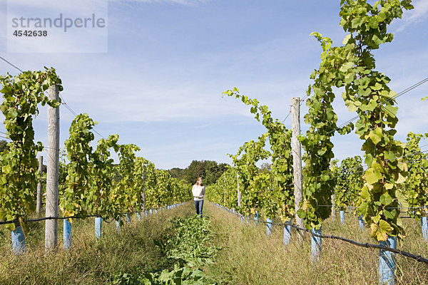 Mittlere erwachsene Frau im Weinberg mit Reben