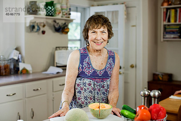 Seniorin in der Küche mit Obst und Gemüse