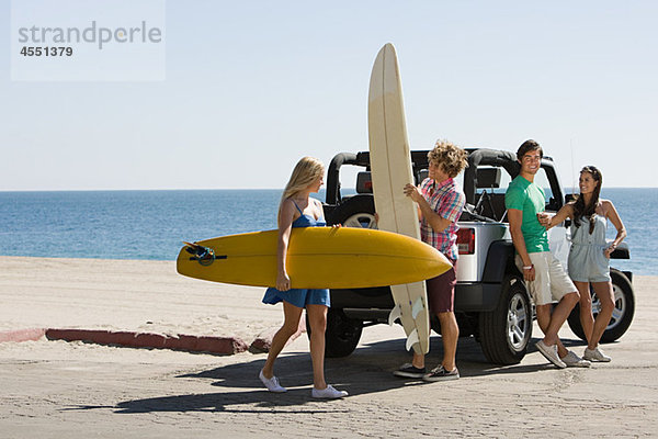 Freunde per Fahrzeug mit Surfbrettern