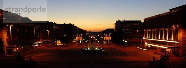 Ausblick auf Platz und Brunnen in der Dämmerung