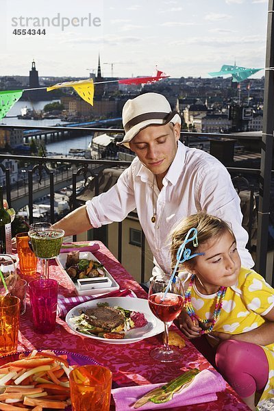 Vater mit Essen am outdoor Cafe Tisch Tochter