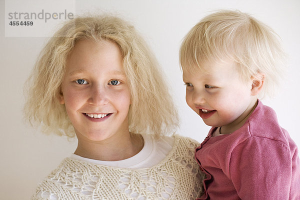 Porträt des Mädchens mit Schwester und lächelnd