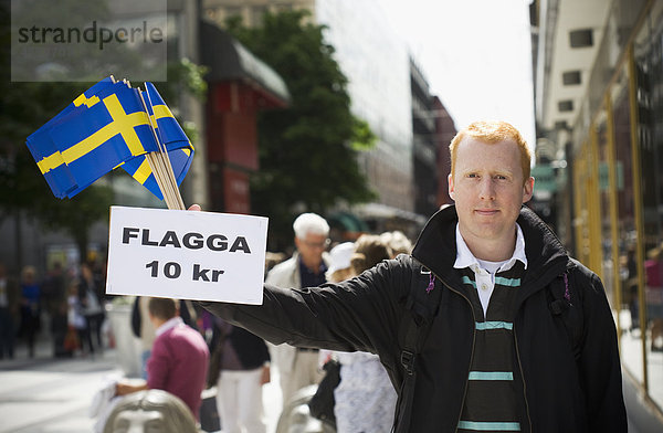 Junger Mann verkaufen schwedischen flags