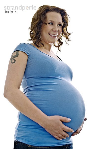 Pregnant Frau hält Bauch  lächelnd