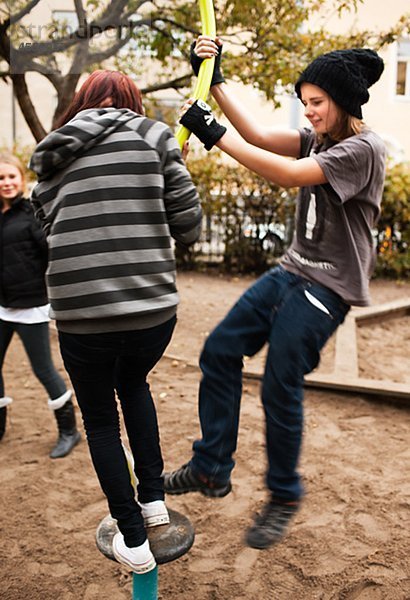 Jugendliche spielen auf Klettergerüst im Schulhof