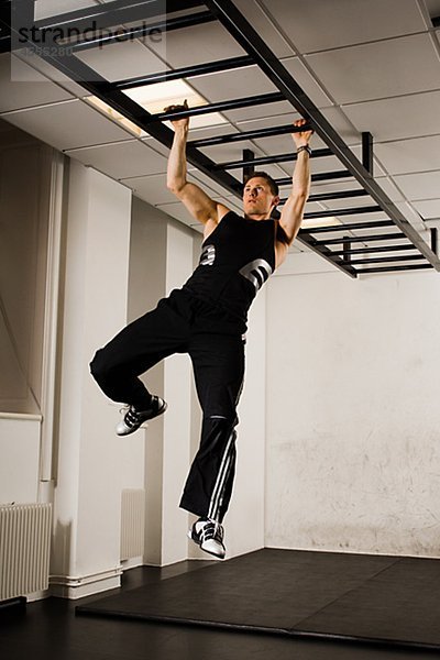 Männlich Athlet mit Gymnastik Ausrüstung im Fitness-Studio