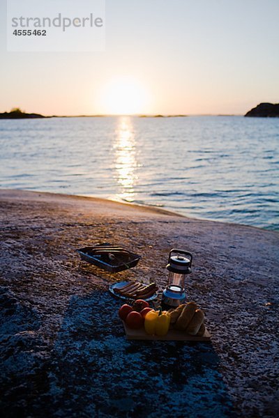 Barbecue-Ausrüstung auf dem Seeweg bei Sonnenuntergang