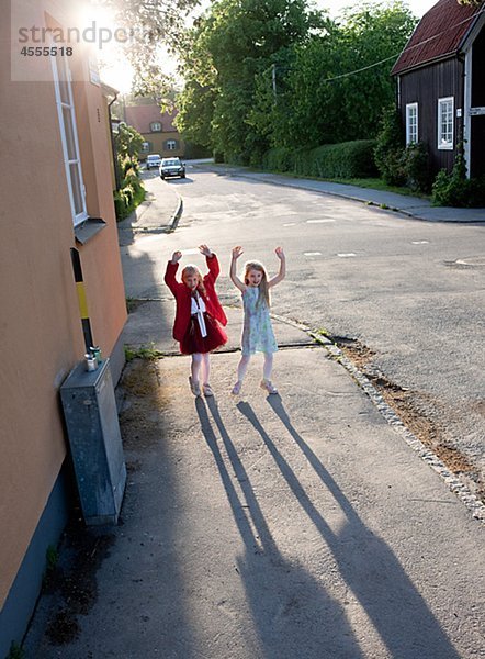 Girls stehen auf Bürgersteig und Erhöhung der Hände