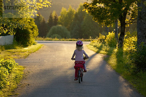 Mädchen Fahrradfahren auf Landstraße