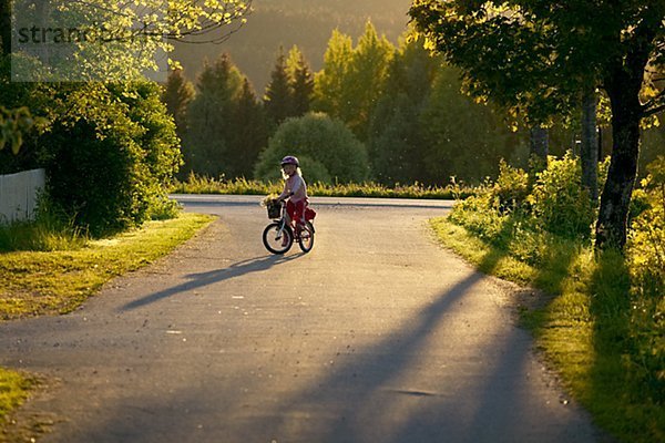 Mädchen Fahrradfahren auf Landstraße
