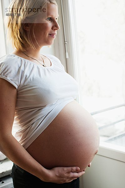 Schwangere Frau durch Fenster Suchen