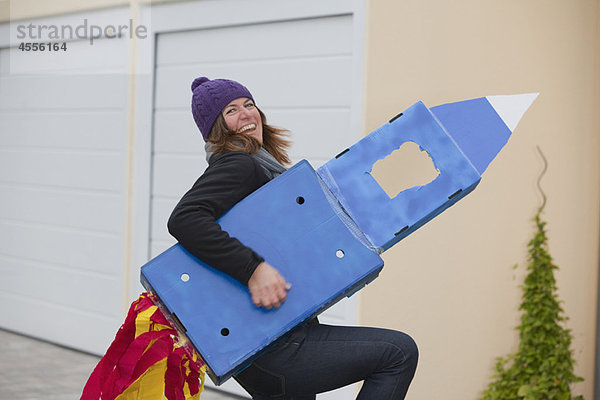 Frau mit selbstgemachter Rakete  lächelnd