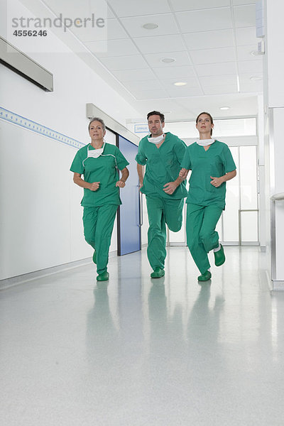 Medizinisches Team im Kittel eilt in die Halle