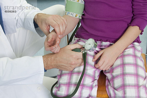 Arzt  der den Blutdruck von Kindern testet