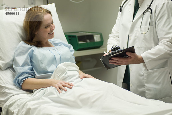 Arzt geht mit Patient im Krankenhaus über die Karte