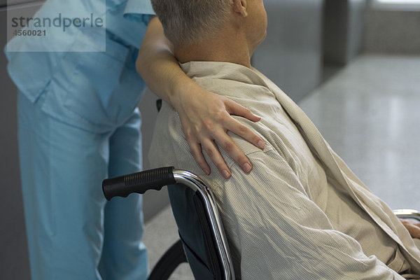 Krankenschwester hilft Patientin im Rollstuhl  abgeschnitten