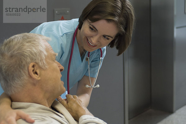 Krankenschwester tröstender Patient im Krankenhausflur