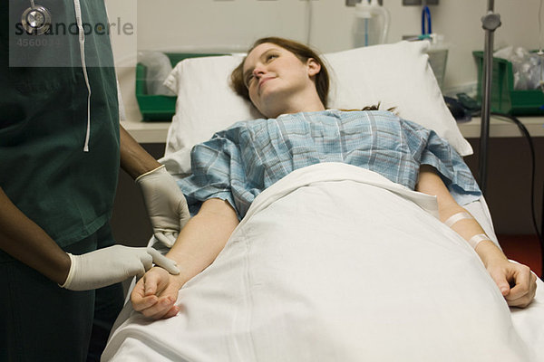 Krankenschwester überprüft den Puls des Patienten