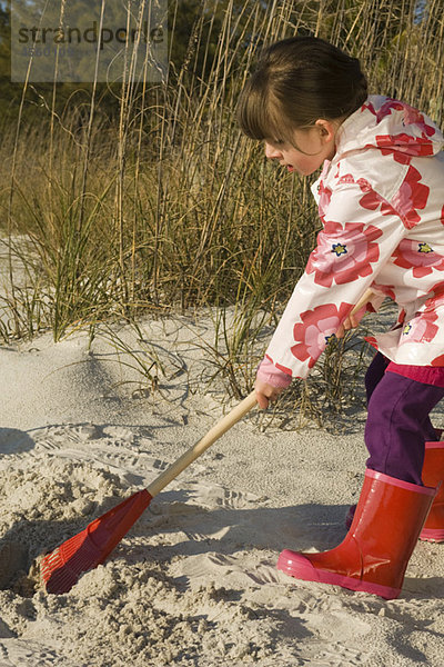 Mädchenrechender Sand