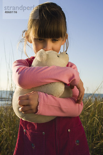Junges Mädchen umarmt Plüschtier Eisbärenjunges