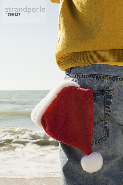 Am Strand mit Blick auf die Aussicht  Weihnachtsmütze in der Gesäßtasche