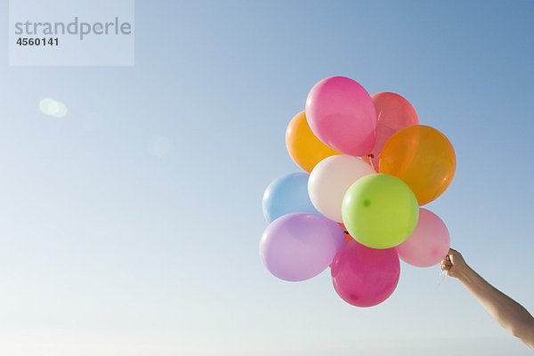 Ein Haufen Heliumballons hielt sich gegen den klaren blauen Himmel.