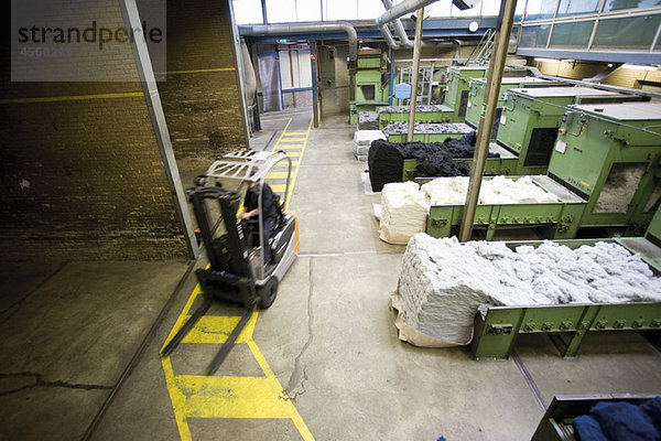 Teppichfliesenfabrik  Gabelstapler  der flauschige Fasern für die Verarbeitung vorbereitet