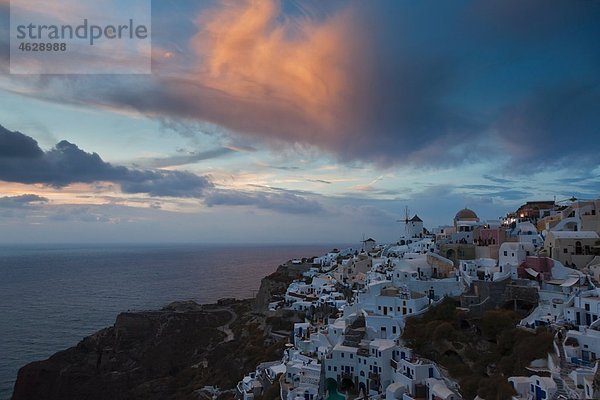 Griechenland  Kykladen  Thira  Santorini  Blick auf Oia und Windmühlen bei Sonnenuntergang