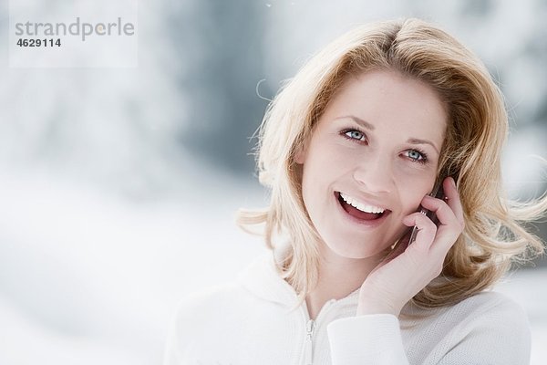 Österreich  Altenmarkt  Junge Frau am Telefon  lächelnd