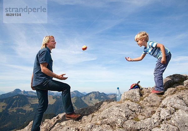 Deutschland  Bayern  Vater und Sohn (4-5 Jahre) spielen auf dem Berggipfel