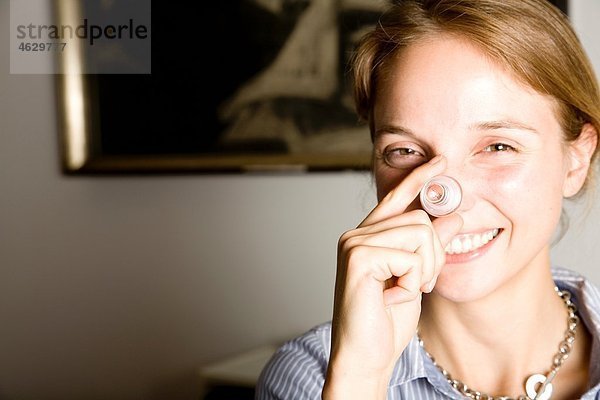 Österreich  Wien  Junge Frau mit Stecker  lächelnd  Portrait
