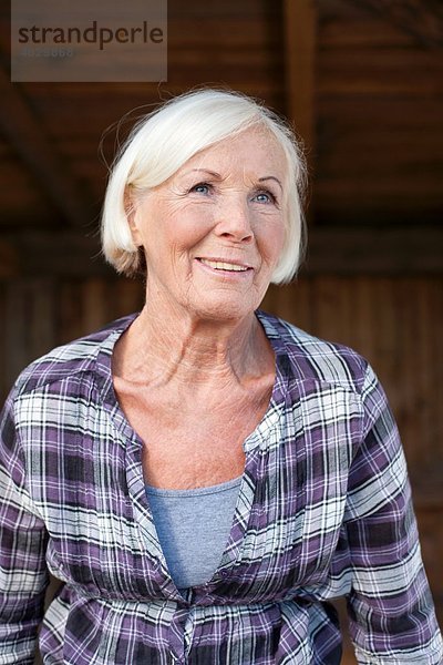 Seniorin auf dem Bauernhof  lächelnd.