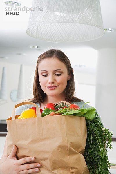 Junge Frau mit Tasche voller Gemüse
