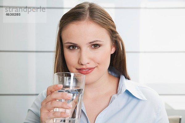 Junge Frau mit Wasserglas  lächelnd  Portrait