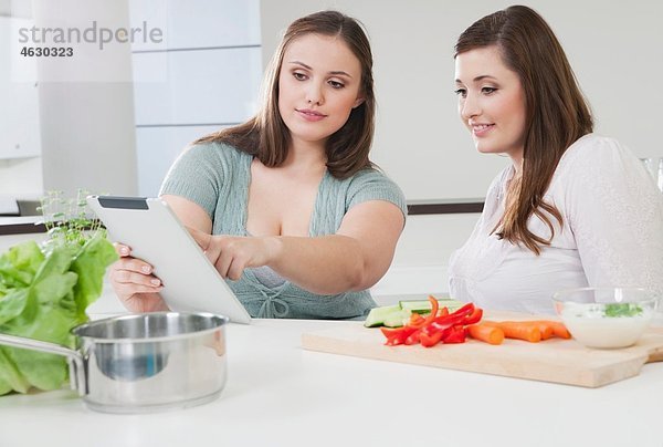 Junge Frauen bereiten gesundes Essen für Diätplan vor