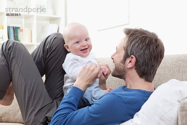 Vater und Baby (6-11 Monate) haben Spaß auf dem Sofa.