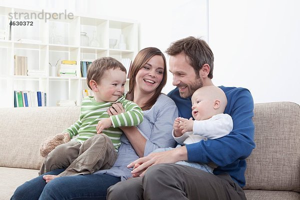 Deutschland  Bayern  München  Familie mit Spaß im Wohnzimmer  Lächeln