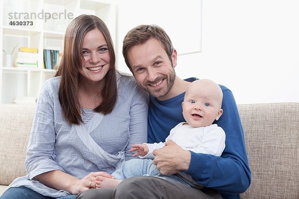 Eltern mit Junge (6-11 Monate)  Portrait  lächelnd