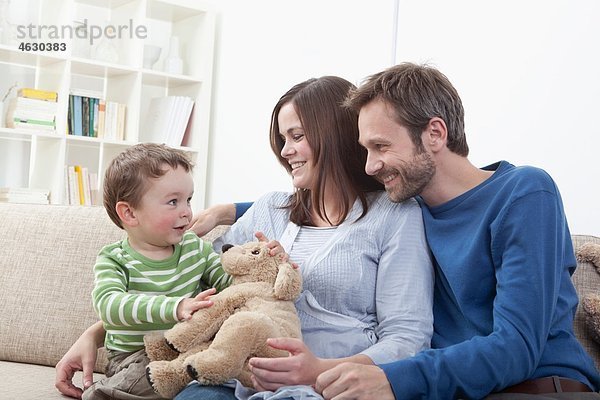 Eltern spielen mit Jungen (2-3 Jahre) im Wohnzimmer
