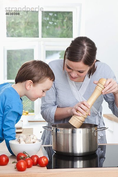 Deutschland  Bayern  München  Mutter und Sohn (2-3 Jahre) bereiten das Essen in der Küche vor.