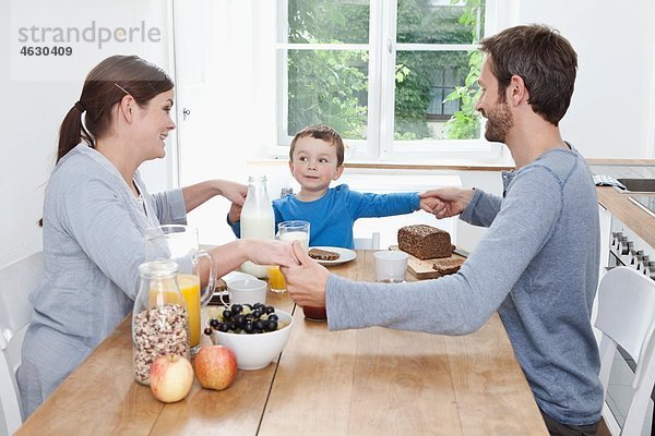 Deutschland  Bayern  München  Familie beim gemeinsamen Frühstücken