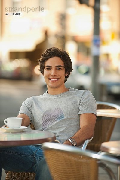Junger Mann im Café  lächelnd  Portrait