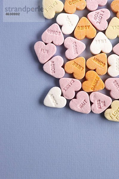 Herzförmige Bonbons mit Text auf grauem Hintergrund