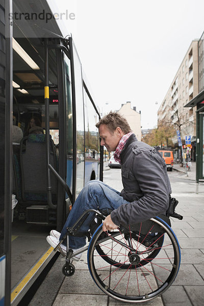 Mann im Rollstuhl rollt im Bus