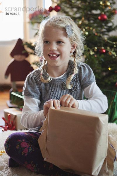 Mädchen eröffnet Weihnachtsgeschenk